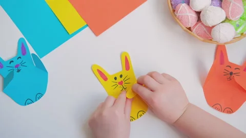 Kids hands opens and closes the paws of a paper bunny Stock Footage 151898039