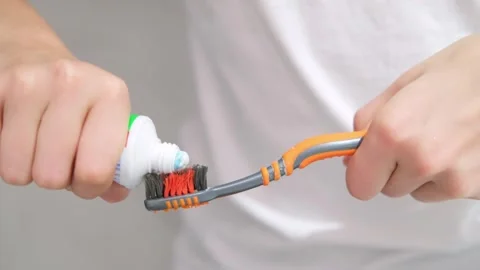 Kids hands squeeze toothpaste onto toothbrush in bathroom at home, Health care Stock Footage 246143082