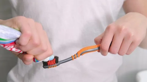 Kids hands squeeze toothpaste onto toothbrush in bathroom at home, Health care Stock Footage 246605636