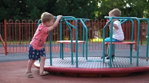 Kids have fun on carousel in the playground Stock Footage 79976259