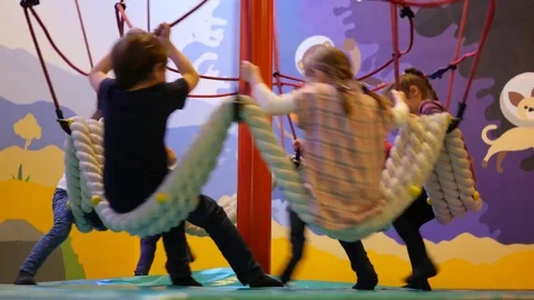 Kids have fun play ride a carousel on indoors playground for children Stock Footage