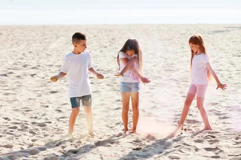 Kids having fun by playing with colored powder 写真素材