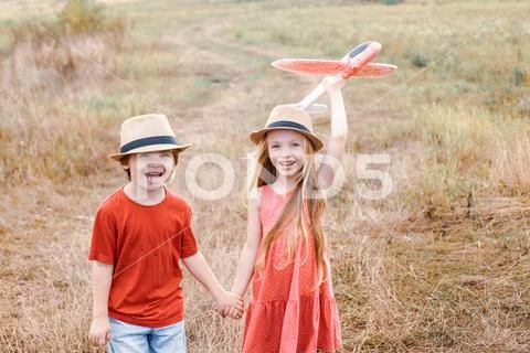 Kids having fun with toy airplane in field against nature background. Happy boy Stock-Fotos