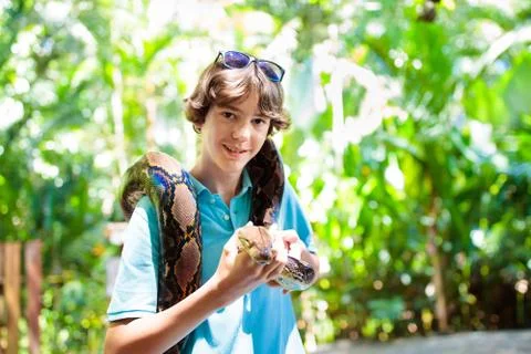Kids hold python snake at zoo. Child and reptile. Foto stock