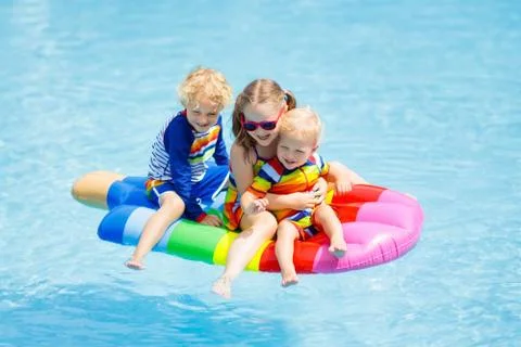 Kids on inflatable float in swimming pool. 스톡 사진