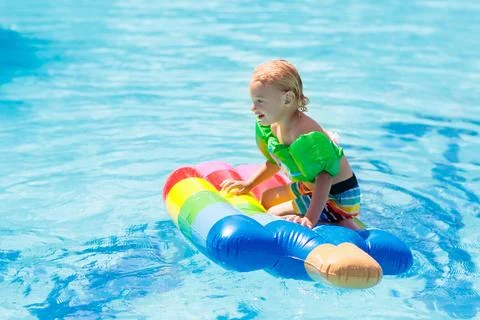 Kids on inflatable float in swimming pool. 스톡 사진