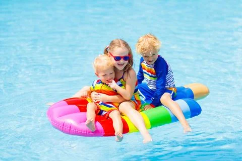 Kids on inflatable float in swimming pool. Stock Photos