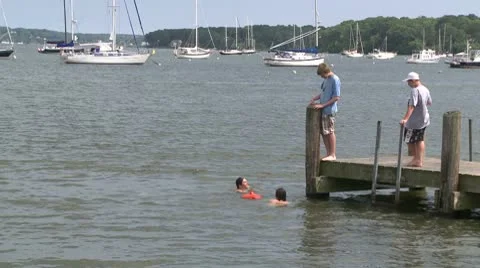 Kids jump off pier into water (2 of 3) Stock Footage