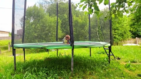 Kids jump on trampoline in backyard during afternoon in sunny weather Stock-Footage 327320819