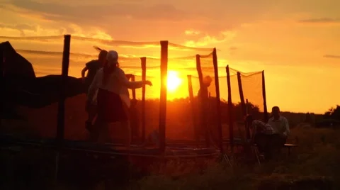Kids jumping on trampoline in sunset 스톡 동영상 58167448