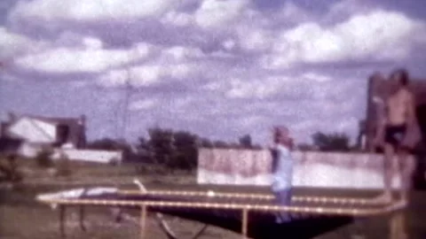 Kids jumping on trampoline in yard Stock Footage 194521371