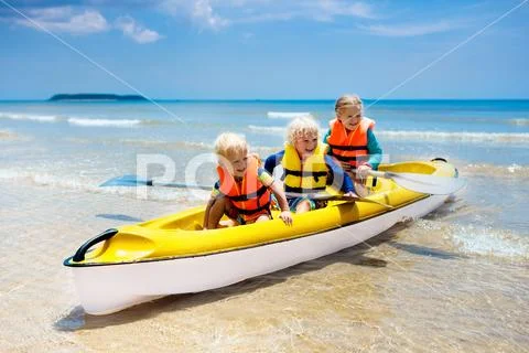 Kids kayaking in ocean. Children in kayak in tropical sea Stock Photos