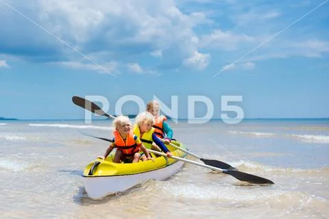 Kids kayaking in ocean. Children in kayak in tropical sea Stock Photos
