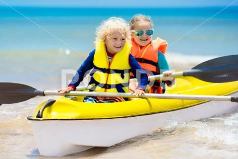 Kids kayaking in ocean. Children in kayak in tropical sea Stock Photos