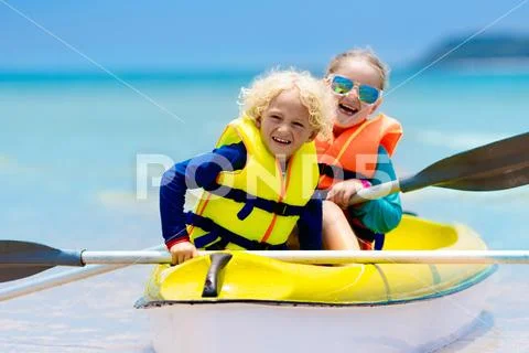 Kids kayaking in ocean. Children in kayak in tropical sea Stock Photos