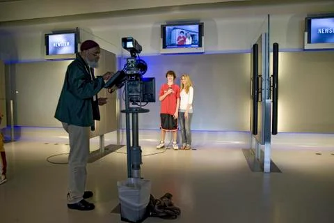 Kids learning how to be on-camera reporter in interactive exhibit at the Newseum Stock Photos