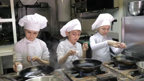 Kids learning how to cook eggs in a cooking class in restaurant kitchen Stock Footage 150311868