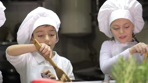 Kids learning how to cook eggs in a cooking class in restaurant kitchen Stock Footage 150312048