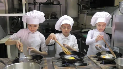 Kids learning how to cook eggs in a cooking class in restaurant kitchen Stock Footage 150312067