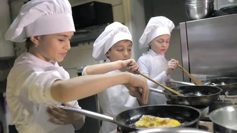 Kids learning how to cook eggs in a cooking class in restaurant kitchen Stock Footage 150312091