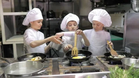 Kids learning how to cook eggs in a cooking class in restaurant kitchen Stock Footage 150312141