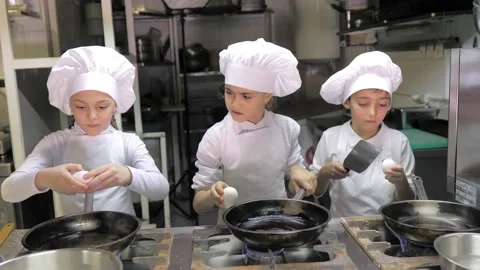 Kids learning how to cook eggs in a cooking class in restaurant kitchen Stock Footage 150312296