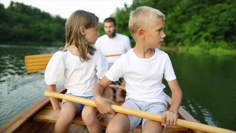 Kids learning to paddle canoe with their dad Stock Footage 249669084