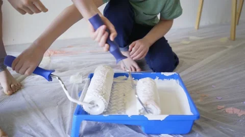 Kids move white rollers in special blue container with paint Stock Footage 133243527