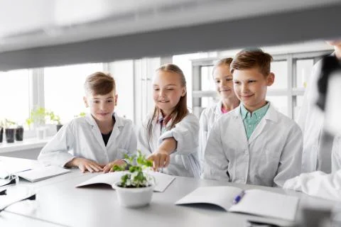 Kids or students with plant at biology class Stock Photos