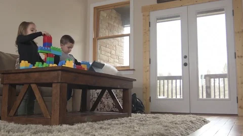 Kids play with building blocks while watching video on tablet  Stock Footage 85365445