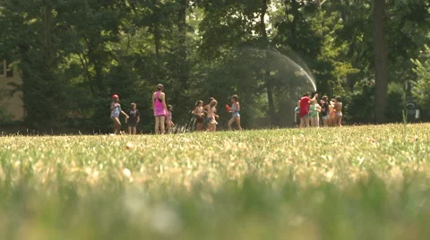 Kids play in a sprinkler Video stock 1049659
