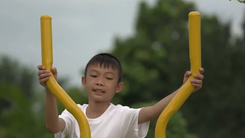 Kids playing and exercing on public outdoor gym park Stock Footage 135546418