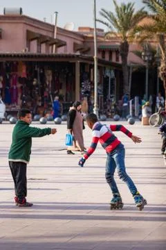 Kids playing and roller skating in a square in Marrakesh, Morocco Stock Photos