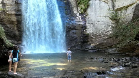 Kids playing at the base of a massive waterfall in North Carolina Video stock 71123741