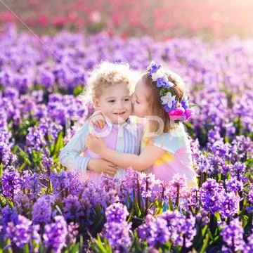 Kids playing in blooming garden with hyacinth flowers Stock Photos