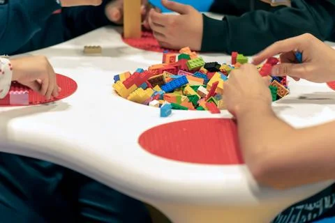 Kids playing with bricks on table Stock Photos