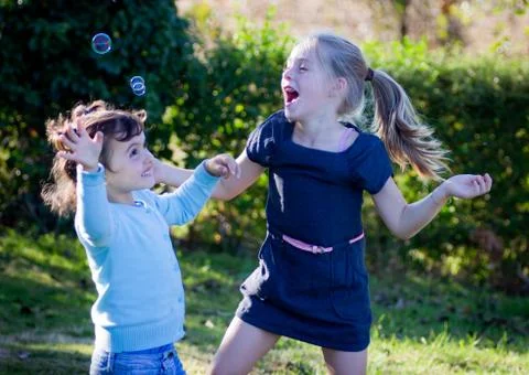 Kids playing with bubbles Stock Photos