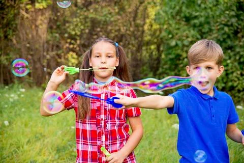 Kids playing with bubbles Stock Photos