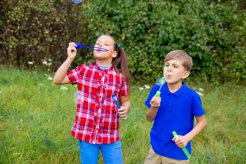 Kids playing with bubbles Stock Photos