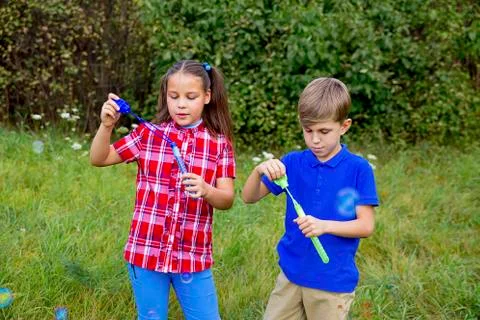 Kids playing with bubbles Stock Photos