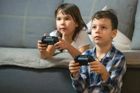 Kids playing console games durring covid 19 outbreak Stock Photos