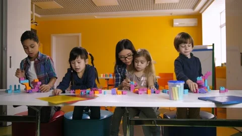 Kids playing with construction blocks in classroom Stock Footage 100047890