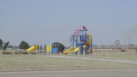 Kids playing on empty lonely playground Stock Footage 104872724