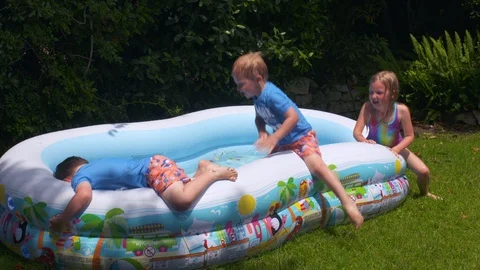 Kids playing in an inflatable pool Video stock 112946466
