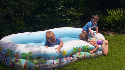 Kids playing in an inflatable pool Stock Footage 112946727