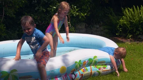 Kids playing in an inflatable pool Stock Footage 112947228