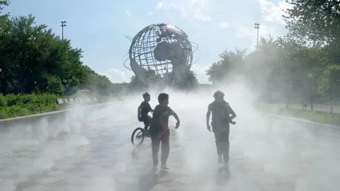Kids playing inside “MIST GARDEN”. Unisphere in the background. 4K. Stock Footage 199702767
