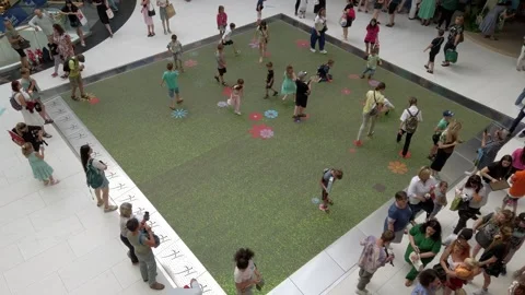 Kids playing with interactive floor in the mall. Interactive floor with flowers. Stock Footage 247971562