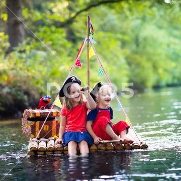 Kids playing pirate adventure on wooden raft Stock Photos