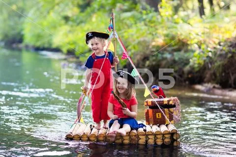 Kids playing pirate adventure on wooden raft Stock Photos